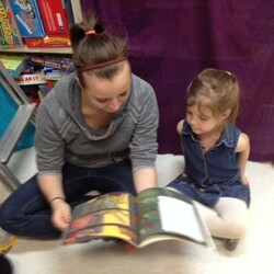 girls reading a book together at library